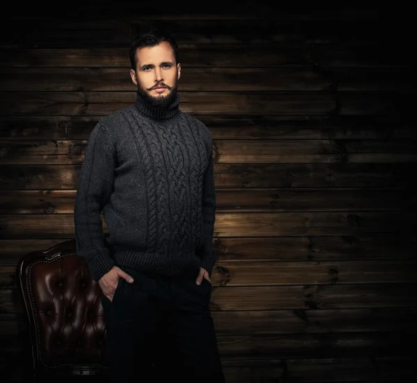 Handsome man wearing cardigan in wooden rural house interior — Stock Photo, Image