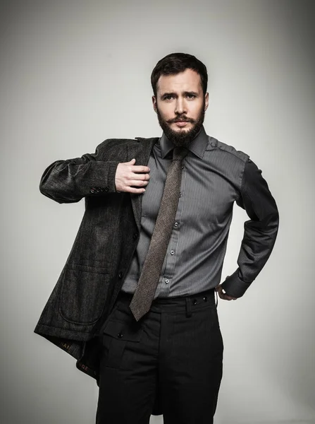 Hombre guapo con barba poniéndose la chaqueta — Foto de Stock