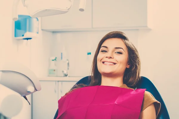 Mujer morena joven con hermosa sonrisa dentista visitante —  Fotos de Stock