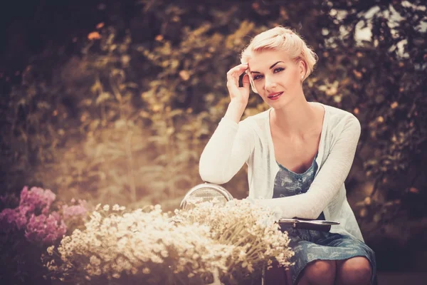 Krásná blonďatá žena sedící na retro roller — Stock fotografie