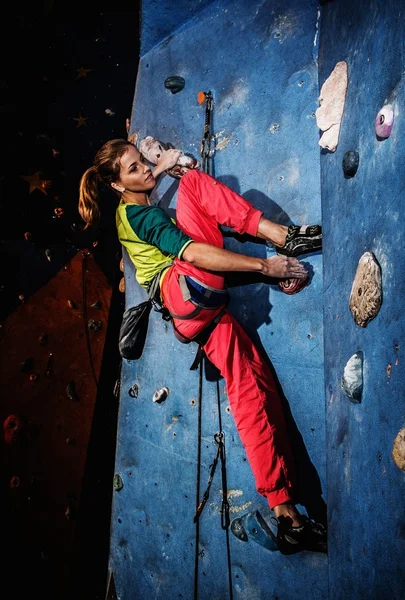 Junge Frau übt sich im Klettern an einer Felswand — Stockfoto