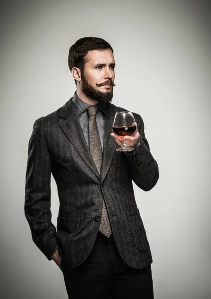 Gutaussehender, gut gekleideter Mann in Jacke mit Getränkeglas — Stockfoto