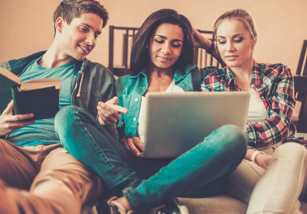 Drei junge Studenten bereiten sich im heimischen Interieur auf Prüfungen vor — Stockfoto