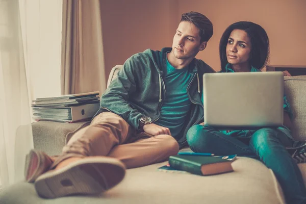 Mladí multi etnické studenti pár připravují na zkoušky v domácí interiér — Stock fotografie