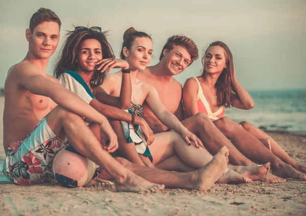Grupo de amigos multi étnicos relaxando em uma praia — Fotografia de Stock