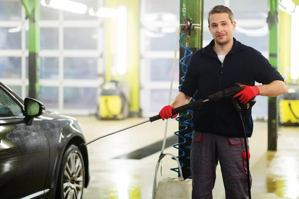 Arbetaren tvätt lyxbil på en biltvätt — Stockfoto