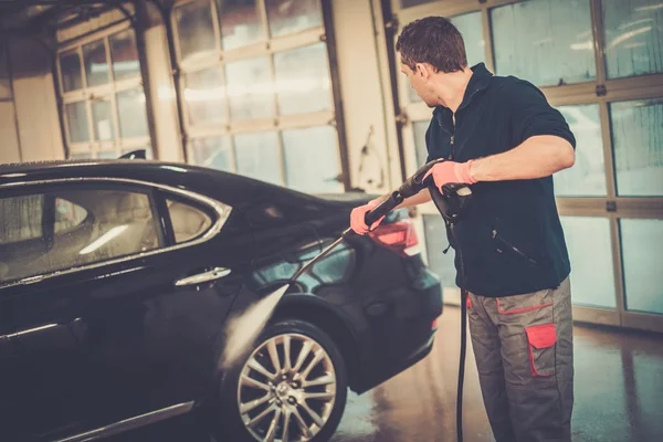 Arbeiter wäscht Luxuswagen in einer Waschanlage — Stockfoto