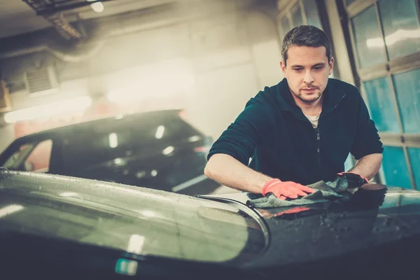 Trabalhador limpando carro em uma lavagem de carro — Fotografia de Stock