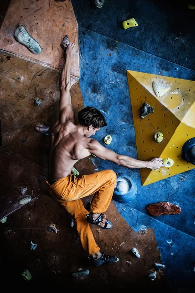 Homem praticando escalada em uma parede de rocha — Fotografia de Stock
