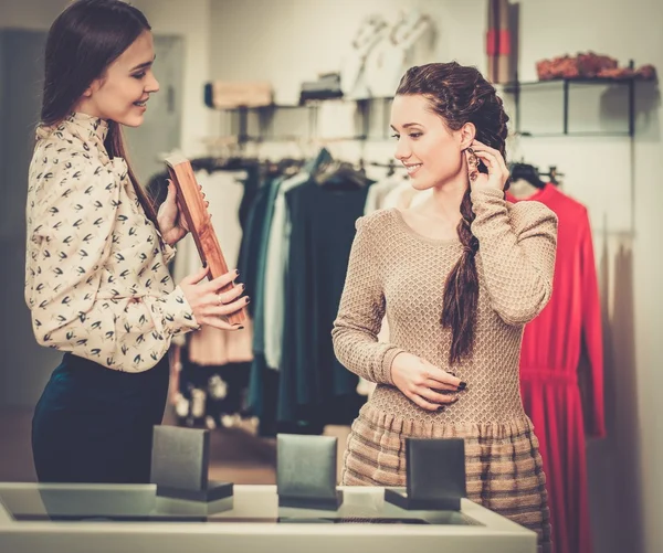 Vrouw kiezen juwelen met winkelbediende help — Stockfoto