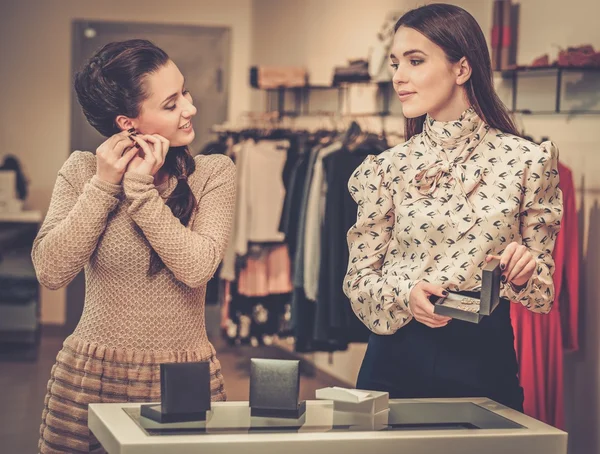 Mujer eligiendo joyas con ayuda de asistente de tienda —  Fotos de Stock