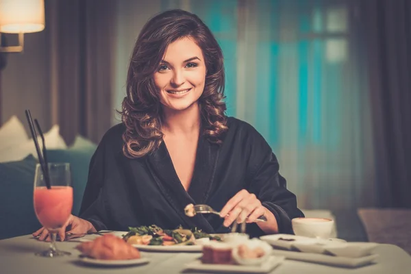 Kvinna med frukost i ett hotellrum — Stockfoto