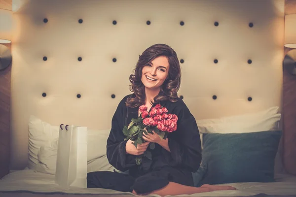 Femme avec bouquet de roses et sac cadeau — Photo