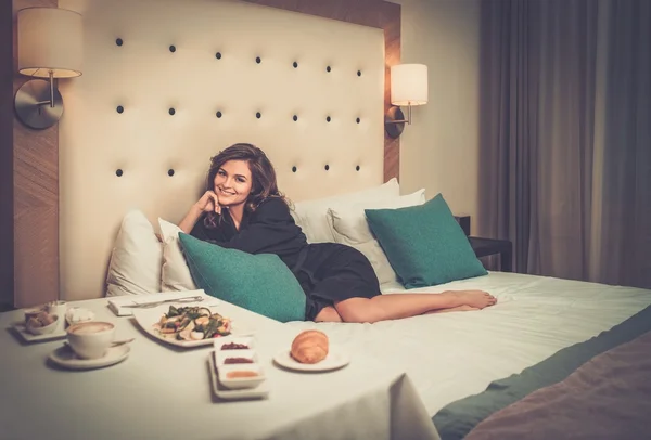 Mulher bonita tomando café da manhã em um quarto de hotel — Fotografia de Stock