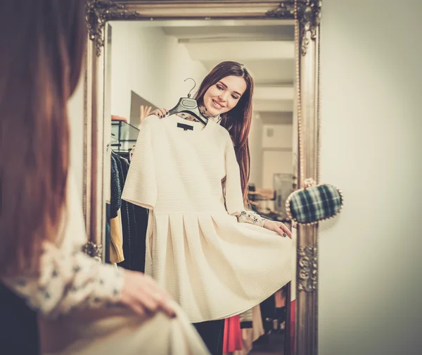 Jovem mulher escolhendo roupas em um showroom — Fotografia de Stock