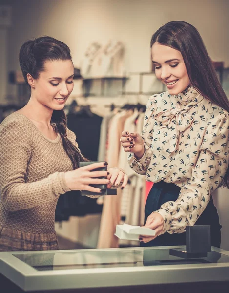 Ung kvinna att välja smycken med shop assistent hjälp — Stockfoto