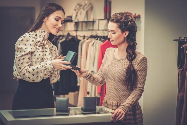 Jeune femme choisir des bijoux avec l'aide d'un assistant de magasin — Photo