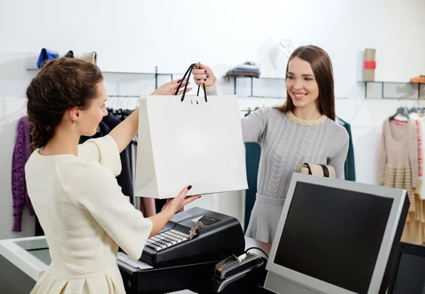 Cliente feliz com saco de compras no showroom de moda — Fotografia de Stock