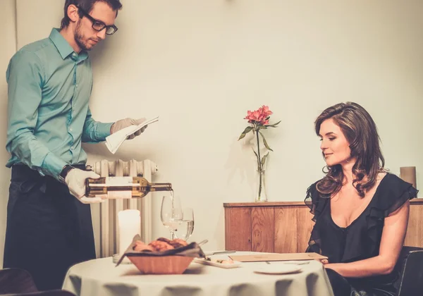 Waiter offering wine to lady in restaurant — Stock Photo, Image