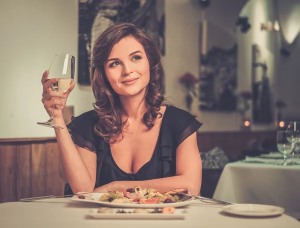Beautiful young lady alone in restaurant — Stock Photo, Image