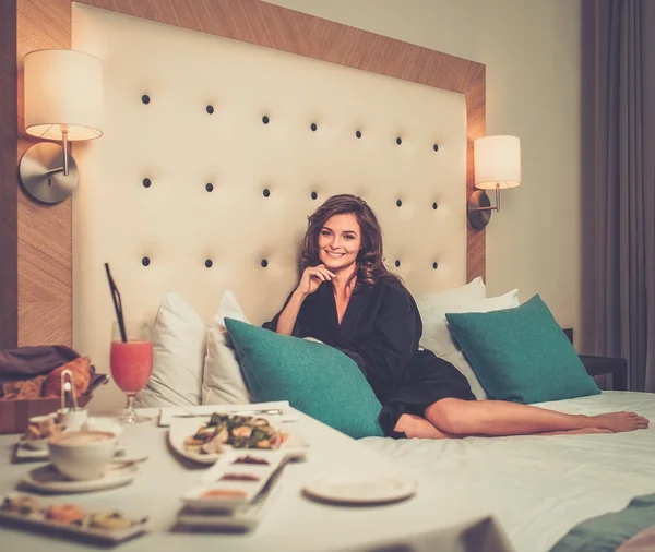 Kvinna med frukost i ett hotellrum — Stockfoto