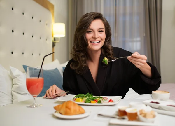 Frau frühstückt im Hotelzimmer — Stockfoto