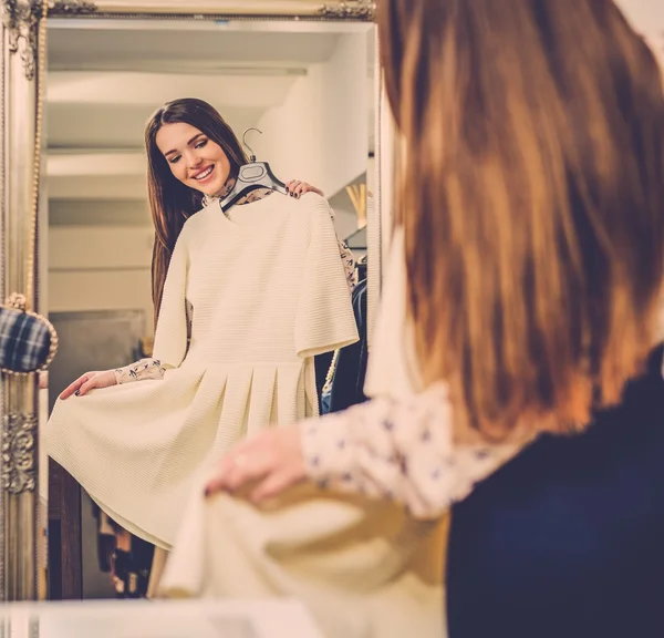 Vrouw kiezen kleren in een showroom — Stockfoto