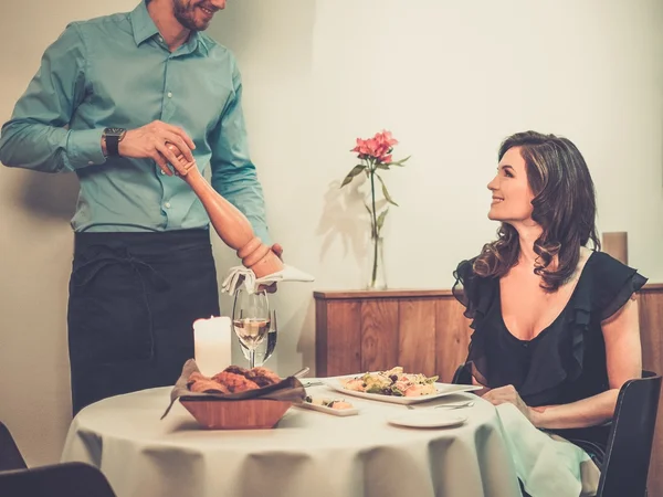 Beautiful young lady and waiter in restaurant — Stock Photo, Image