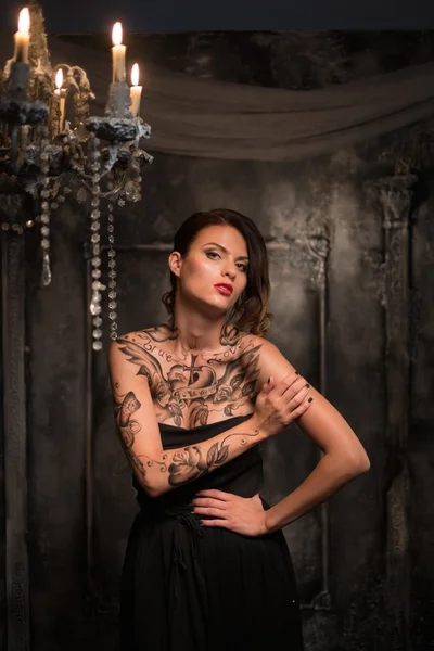 Tattooed woman in old spooky interior — Stock Photo, Image