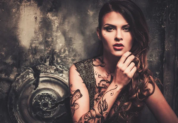 Tattooed woman in old spooky interior — Stock Photo, Image