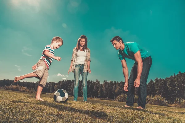 Familj spelar fotboll utomhus — Stockfoto