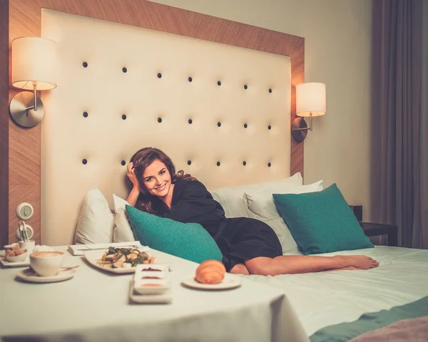 Mulher bonita tomando café da manhã em um quarto de hotel — Fotografia de Stock