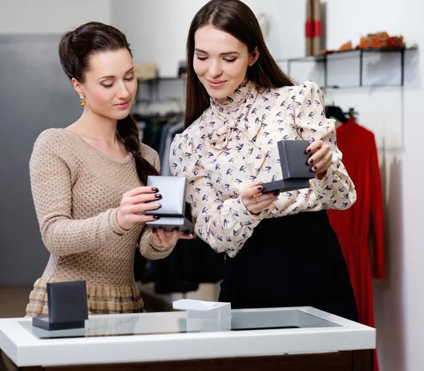 Ung kvinna att välja smycken med shop assistent hjälp — Stockfoto