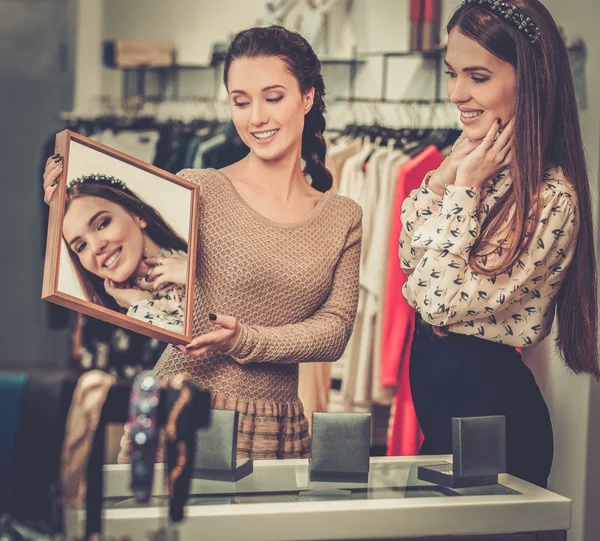 Young woman choosing jewellery with shop assistant  help — Stock Photo, Image