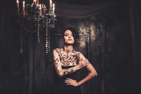 Tattooed woman in old spooky interior — Stock Photo, Image