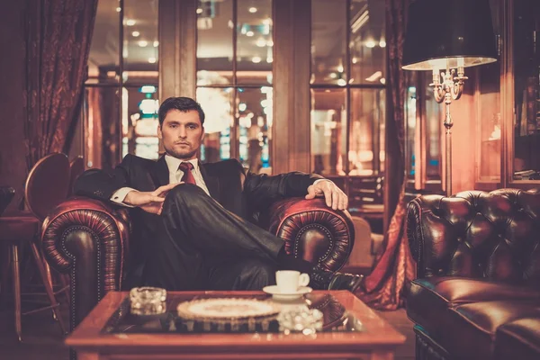 Handsome brunette sitting in luxury interior — Stock Photo, Image