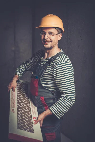 Cheerful builder in helmet carry tile — Stock Photo, Image
