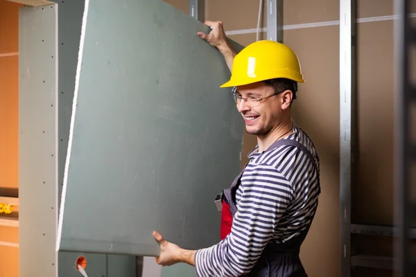 Builder with plasterboard in new building interior — Stock Photo, Image