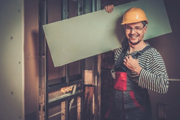 Builder with plasterboard in new building interior — Stock Photo, Image