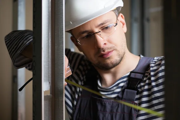 Builder measuring distance with tape — Stock Photo, Image