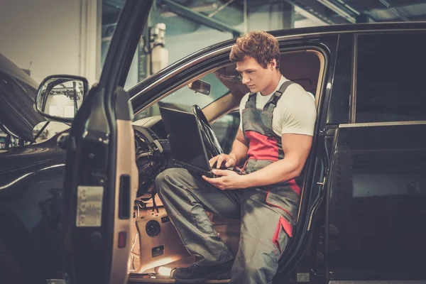 Servicio que hace diagnósticos del coche con el ordenador portátil — Foto de Stock