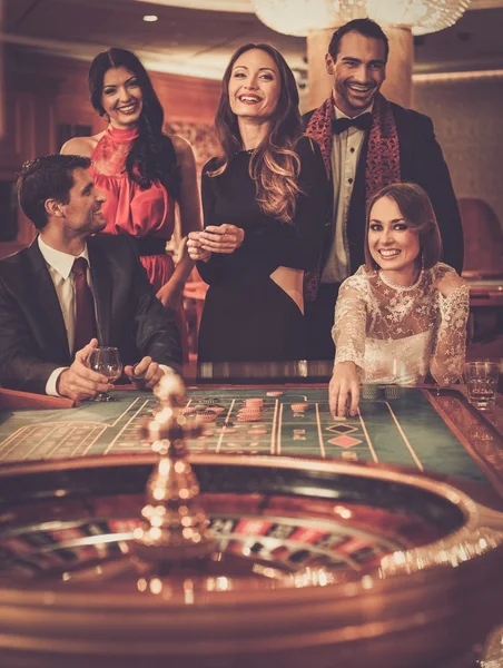 Groupe de personnes élégantes jouant dans un casino — Photo