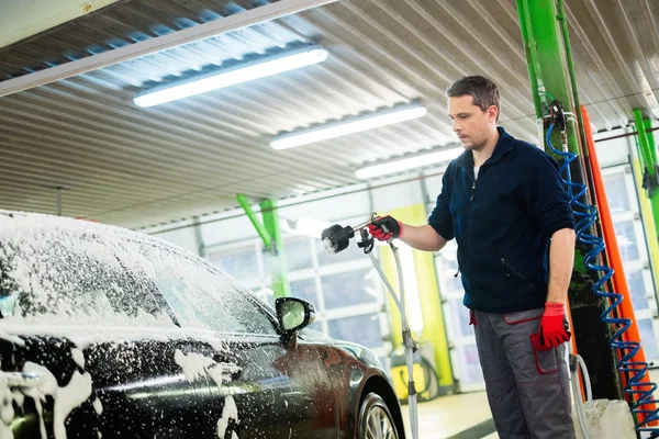 Arbeiter wäscht Luxuswagen in einer Waschanlage — Stockfoto