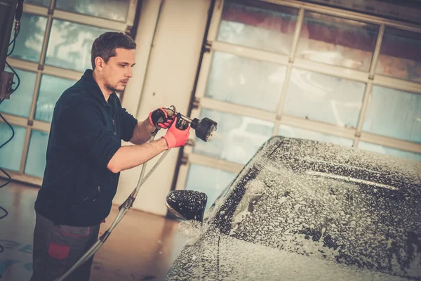 Arbeiter wäscht Luxuswagen in einer Waschanlage — Stockfoto