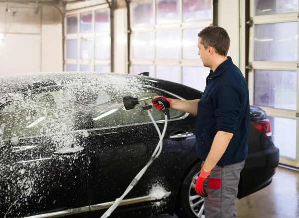 Arbeiter wäscht Luxuswagen in einer Waschanlage — Stockfoto