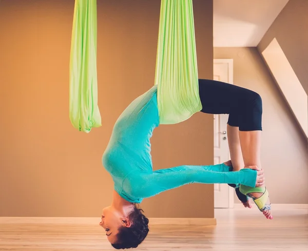 Jonge vrouw uitvoeren van anti-zwaartekracht yoga oefening — Stockfoto