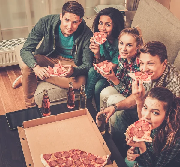 Amigos multiétnicos con pizza y botellas de bebida — Foto de Stock