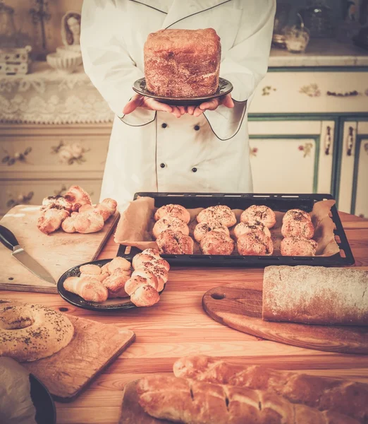 Mulher cozinheiro com prato de produtos caseiros — Fotografia de Stock