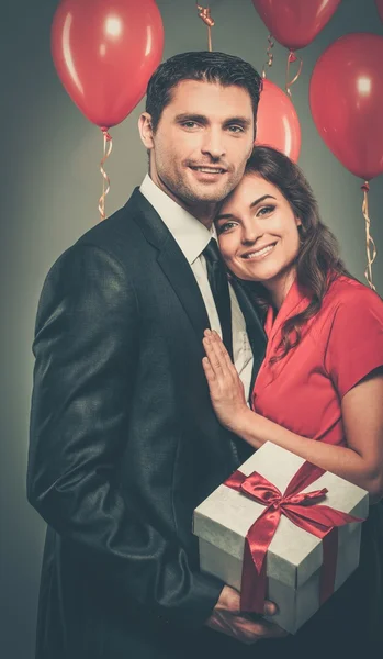 Pareja con globos y caja regalo —  Fotos de Stock