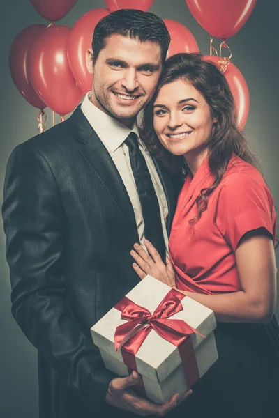 Pareja con globos y caja regalo — Foto de Stock